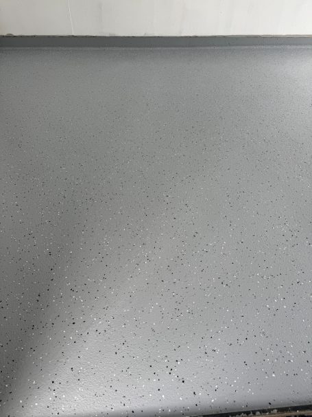 Glatte, graue Oberfläche mit feinen Wassertropfen.